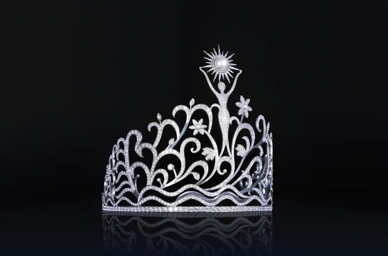 Los elementos florales reflejan la riqueza natural de Puerto Rico. Representan vida, feminidad y crecimiento.  Tiene 78 quilates en Diamantes que representan cada municipio.