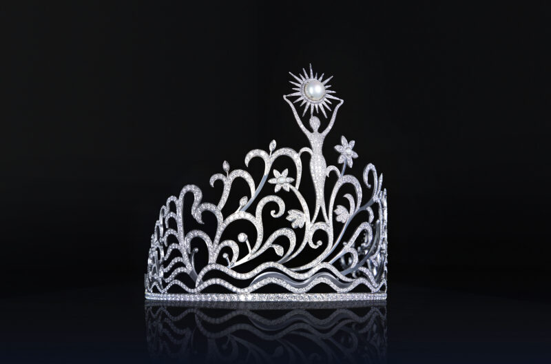 Los elementos florales reflejan la riqueza natural de Puerto Rico. Representan vida, feminidad y crecimiento.  Tiene 78 quilates en Diamantes que representan cada municipio.